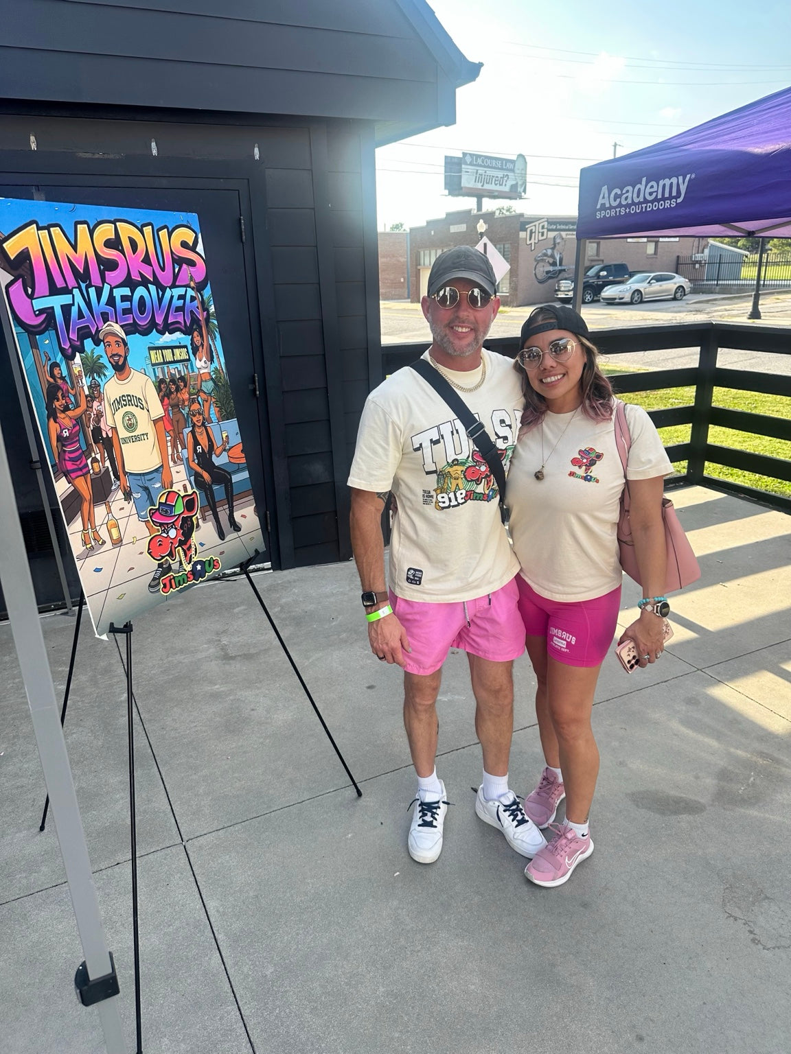 Two JIMSRUS customers wearing branded apparel at an event