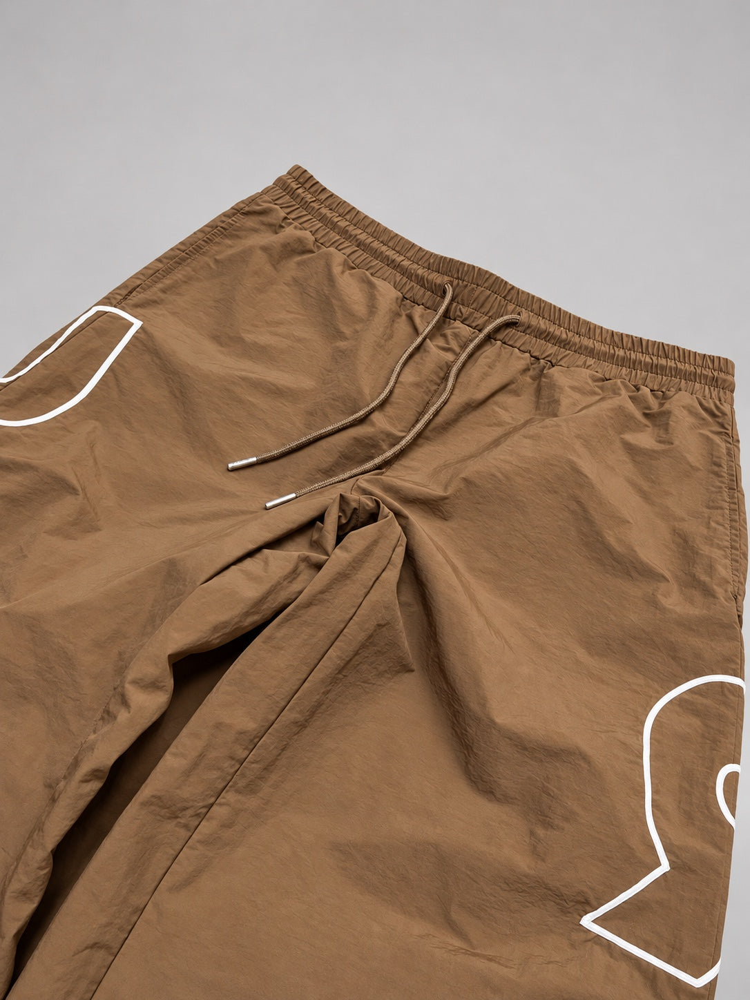 Tan swish pants drawstring and graphic detail